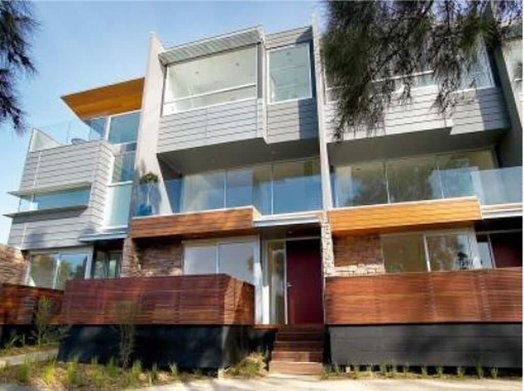 Multi-level residential development with glazed balconies and timber screening